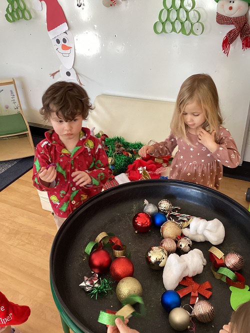 children at a tray full of christmas decorations