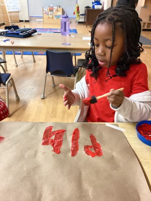child painting their hand orange