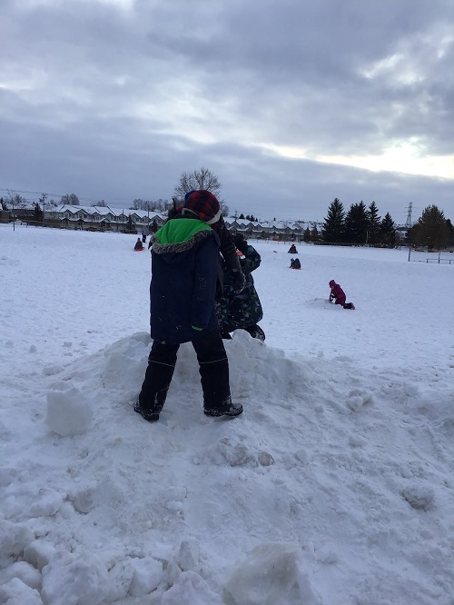 children standing in/on the snow hill