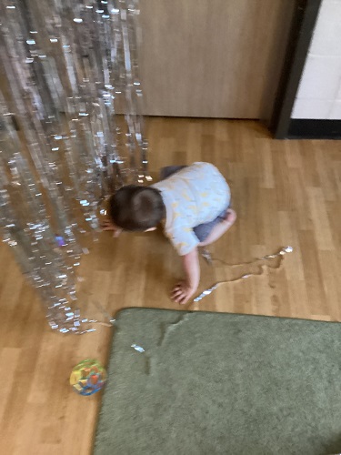 Infant crawling under the tinsel