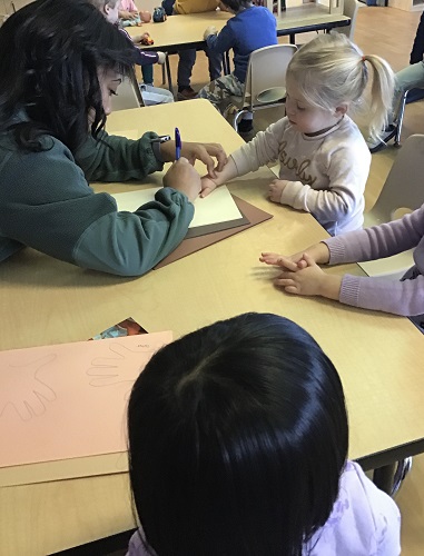 Educator tracing childs hand