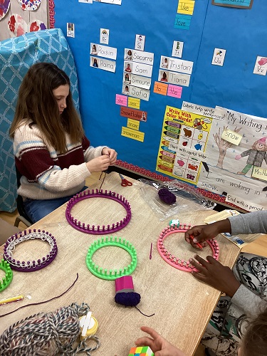 School-age girl starting her knit loom