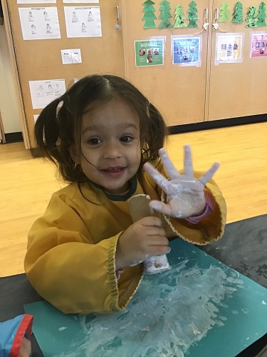 Toddler girl showing off painted hand