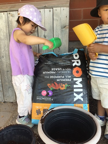 Toddlers helping with planting soil