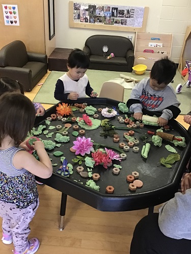 Group of toddlers at tuff tray with playdough