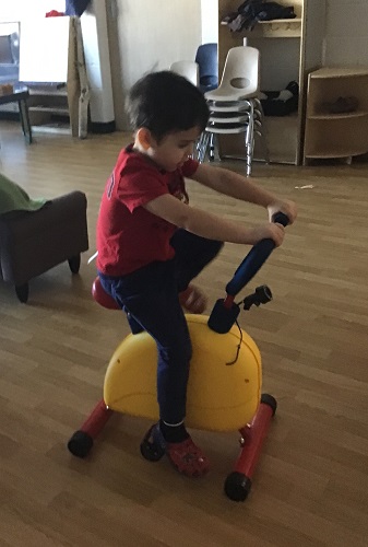 A child riding a child sized exercise bike