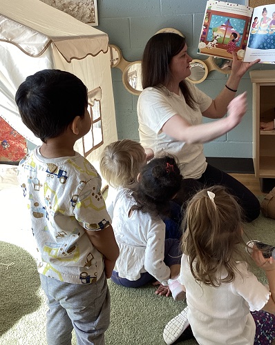 An educator reading a story to the children