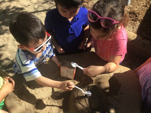 children adding ingredients to volcano