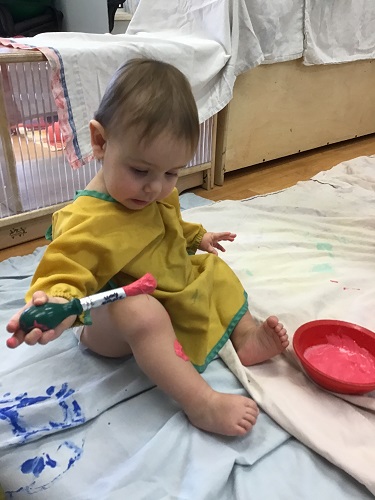 Child painting with paint brush