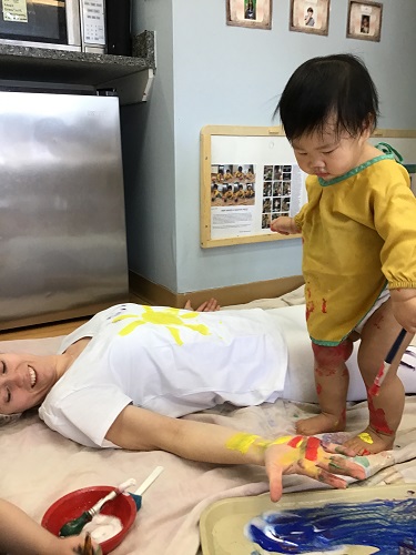 Child Pianting educator with yellow paint