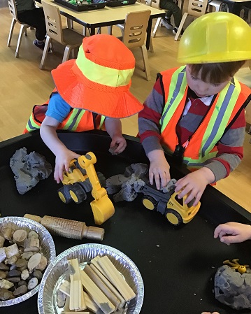 2 preschool boys wearing construction vests and hats 