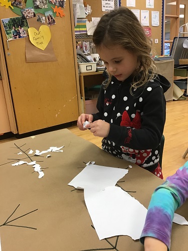 school-age girl making snowflake 
