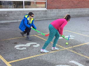 School-age boy and girl playing hockey together