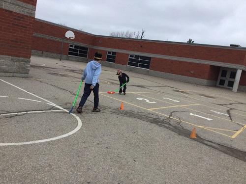 two school-age boys playing hockey