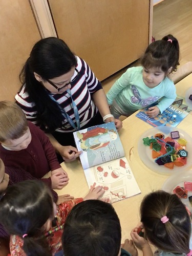 educator reading book to group of preschool friends