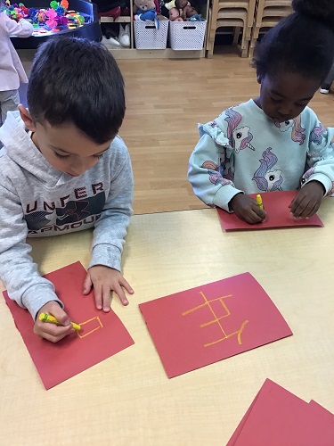 Preschool friends drawing Chinese symbol on paper