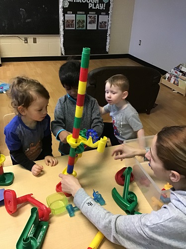 3 Preschool children building with an educator 