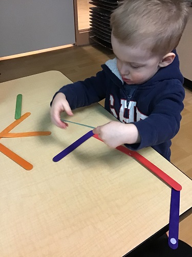 Preschool boy exploring loose part sticks