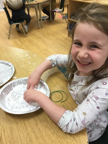 School-age girl moulding fake snow 