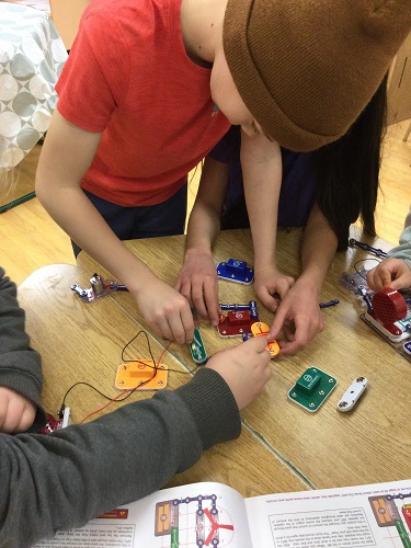 school-age boy building a circuit 