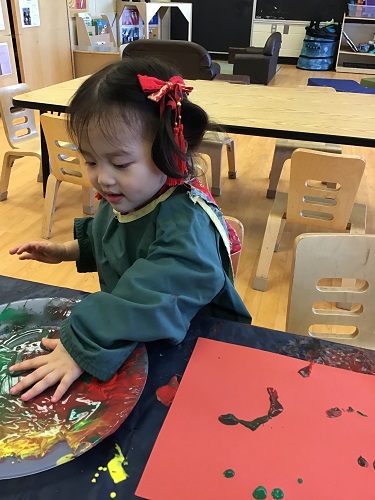 Toddler girl painting with hands