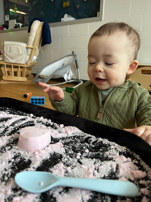 A child exploring with cloud dough.