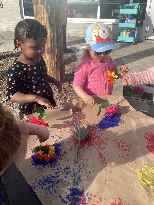 Children painting with flowers