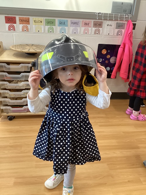 A child wearing a firefighter helmet.