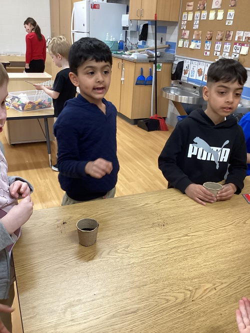 Children standing with their planter cups