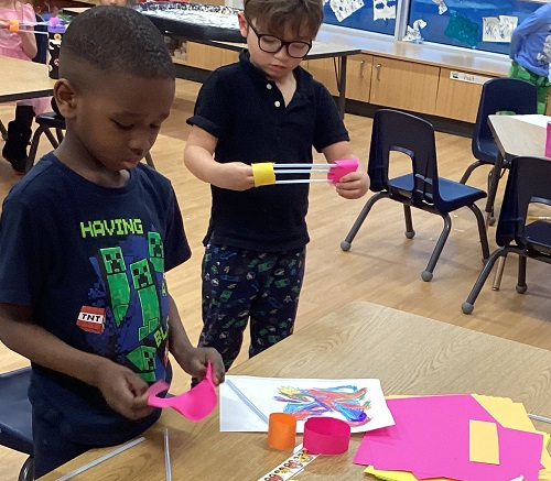 Two children creating airplanes.