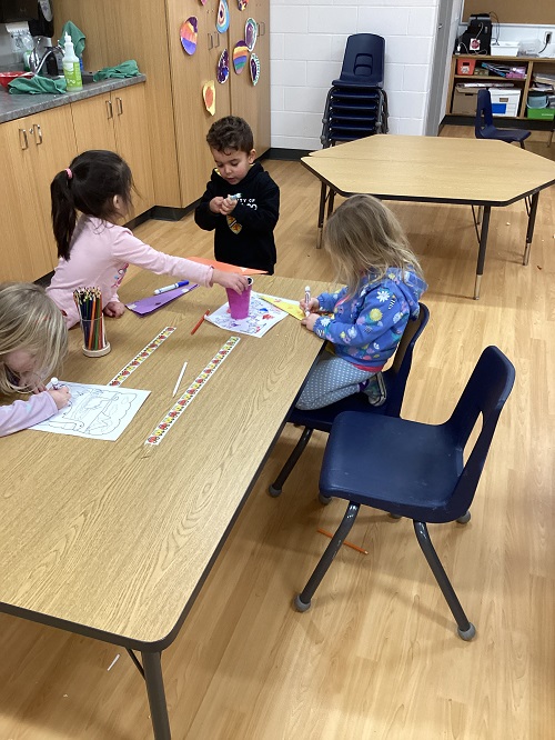 A small group of children creating airplanes.