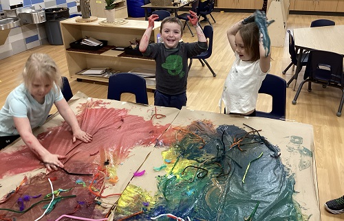 Children exploring with paint at a table