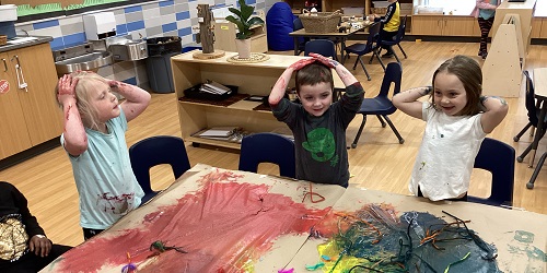 Children exploring with paint at a table