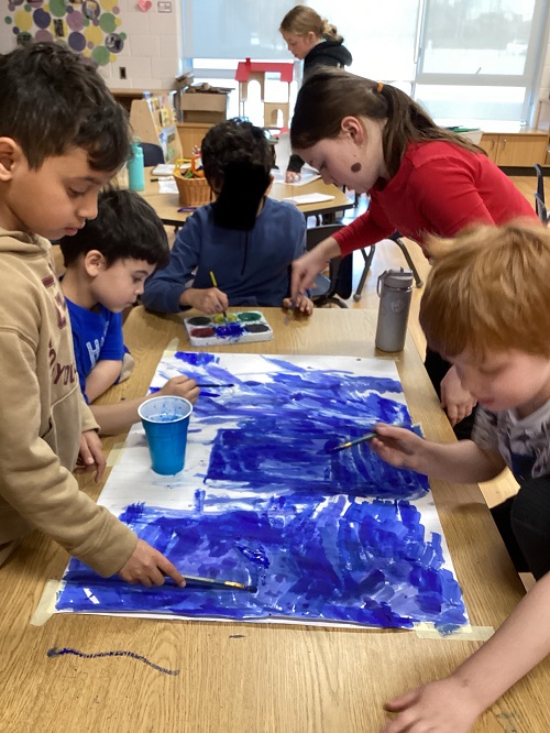A group of children working collaboratively while painting