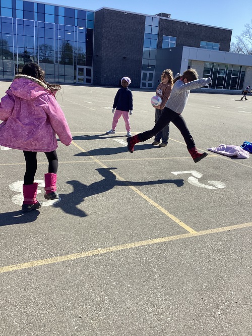 A group of children playing 4-Square.