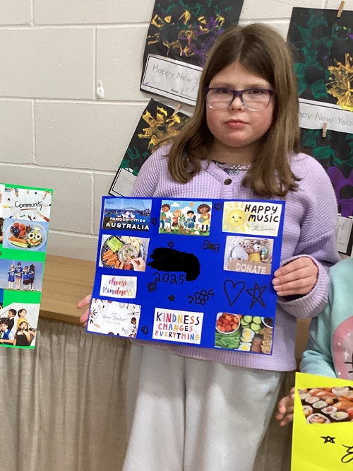 A child displaying the vision board they created.