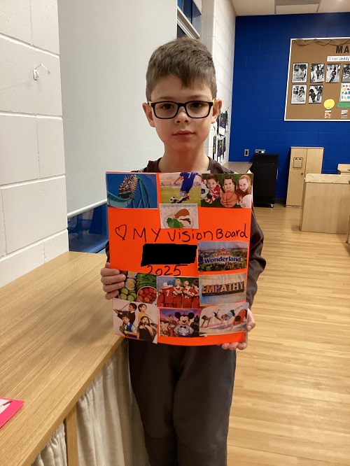 A child displaying the vision board they created.