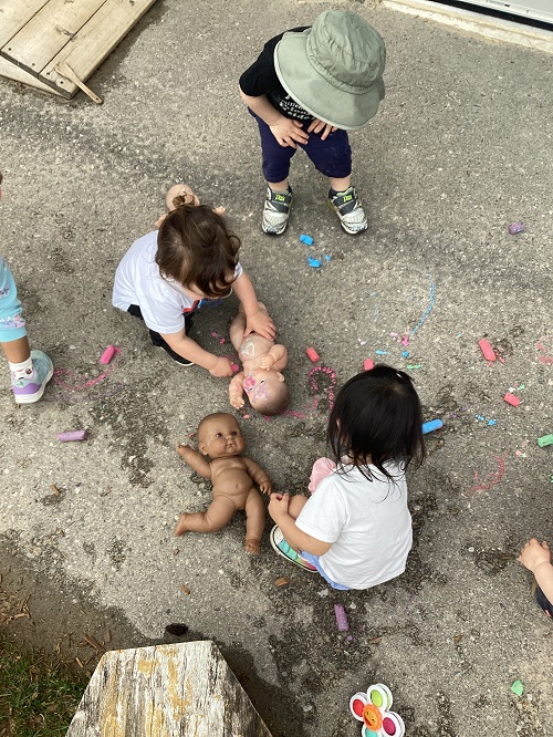 Children tending to their babies on the playground.