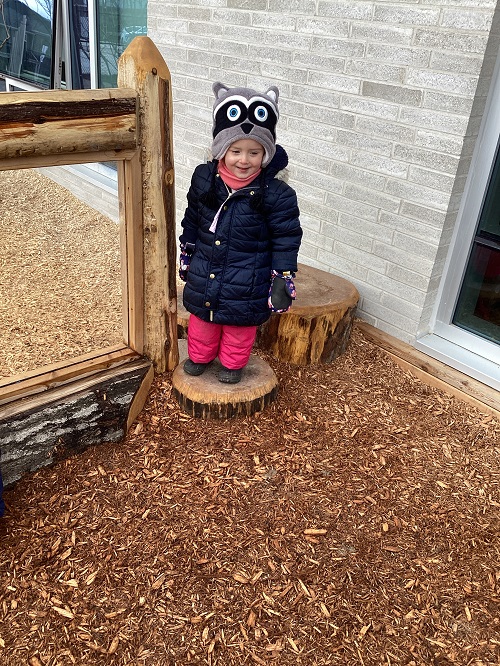 A child standing on a stump.