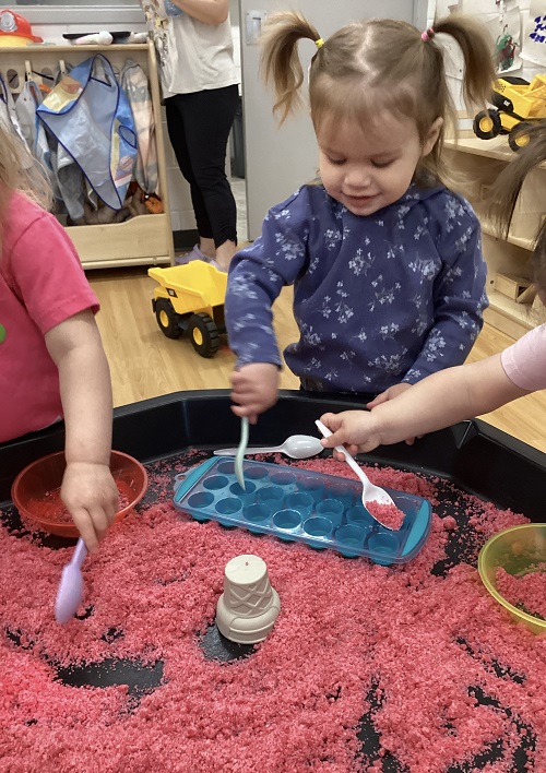 A child engaging with moon dough.