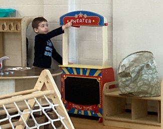 A preschool child pointing at a shape found in the classroom