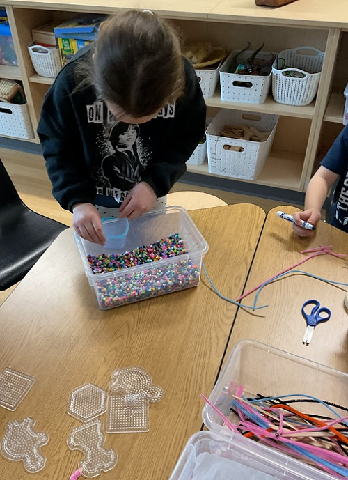 child using recycled beads