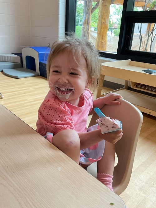 child smiling with popsicle