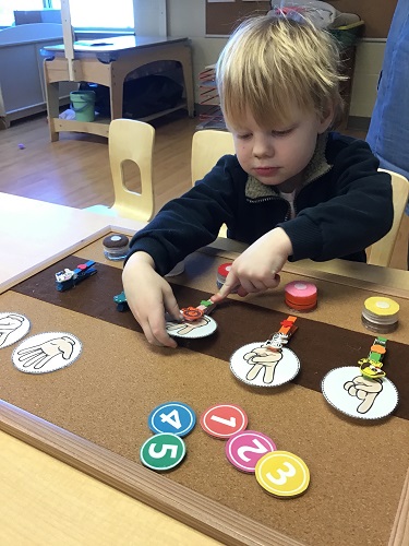 A child putting the matching numbers onto the number board
