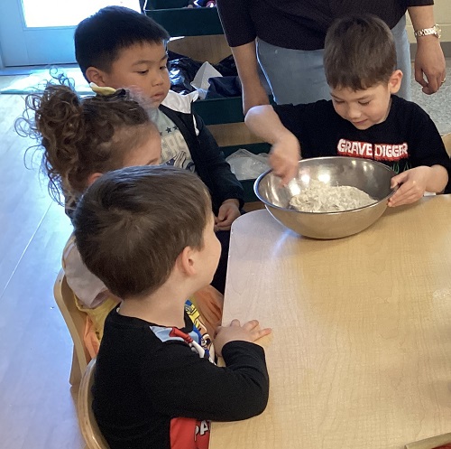 A child mixing flour in a bowl