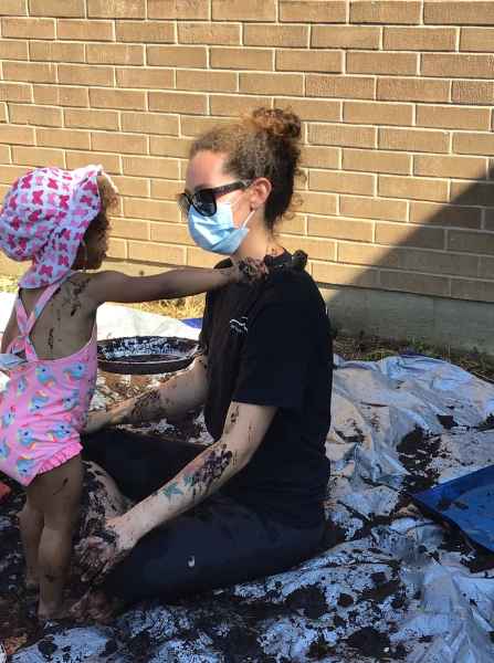 toddlers getting educator all muddy outside