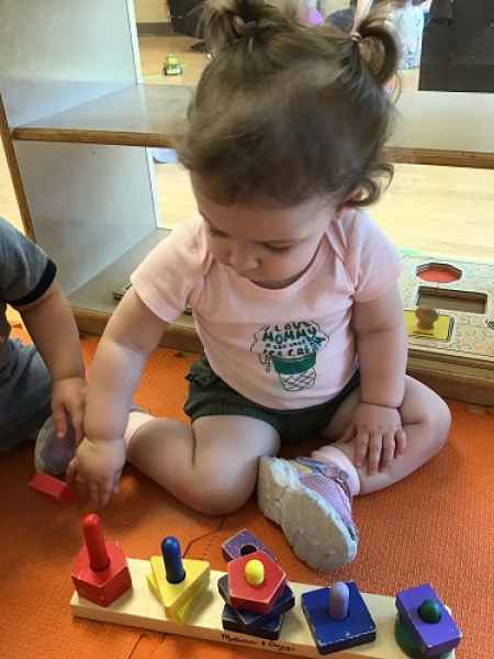 girls playing with a shape sorter