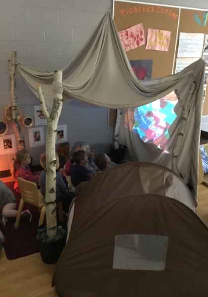 children watching a movie projected on a tarp