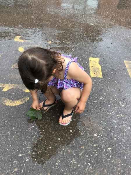girl observing a puddle