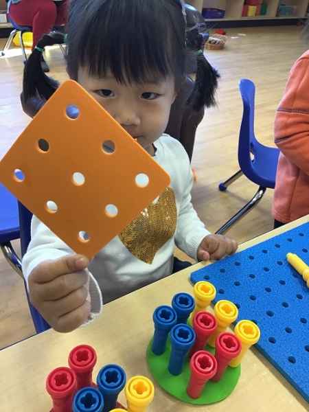 girl playing with foam peg board